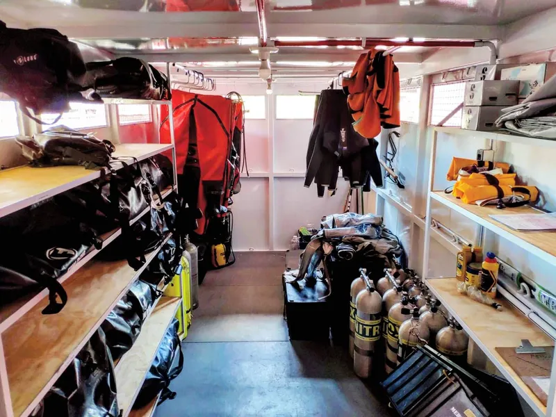 Interior do container da unidade de mergulho com prateleiras de equipamentos
